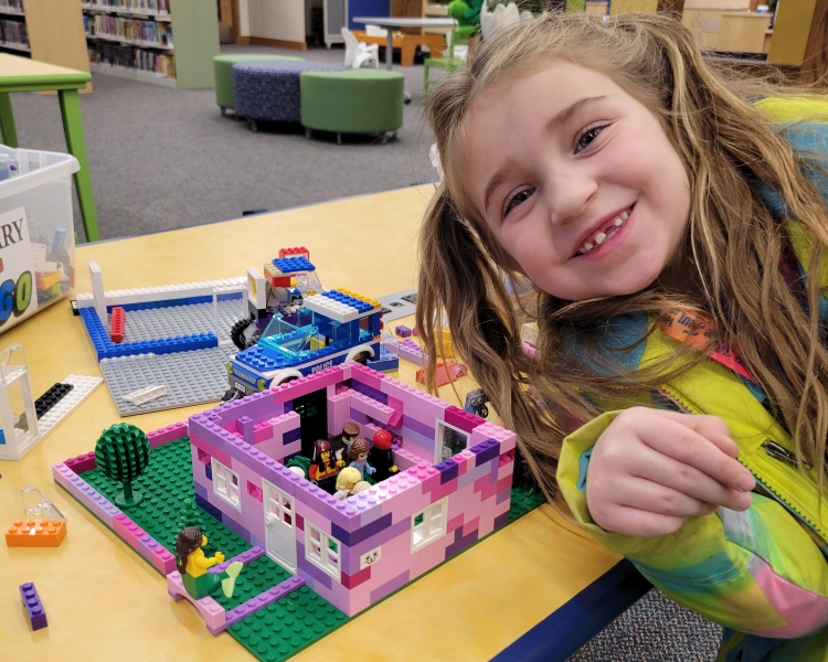 Young girl smiling in front of lego project